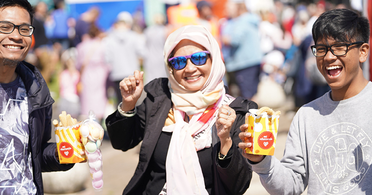 two young men and woman smiling and eating churros at Seaham Food Festival